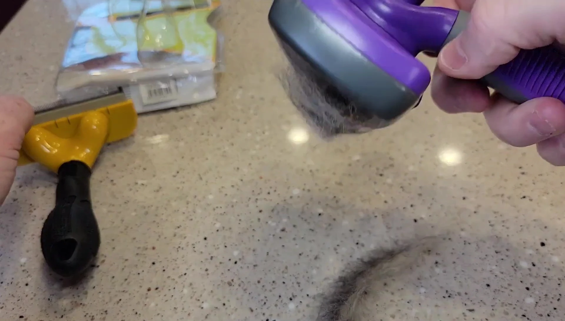 Cleaning the Furminator brush by pressing the button and wiping.