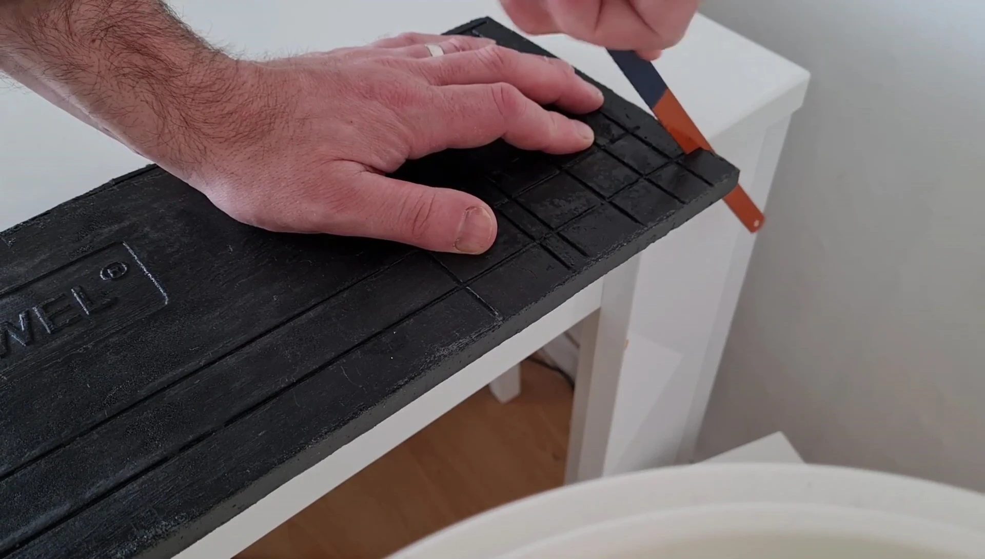 The hacksaw blade and cut background panel