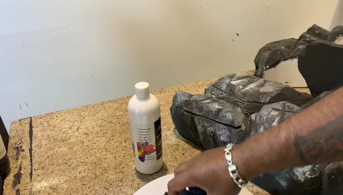 Add shading to the rocks using an old sponge and acrylic paint to achieve a more natural look.