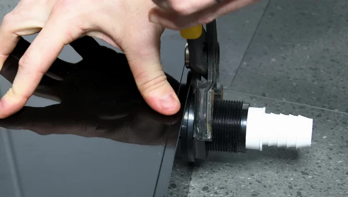 Install bulkheads and plumbing components in the sump and overflow box, using PVC cement and hose clamps to create watertight seals.