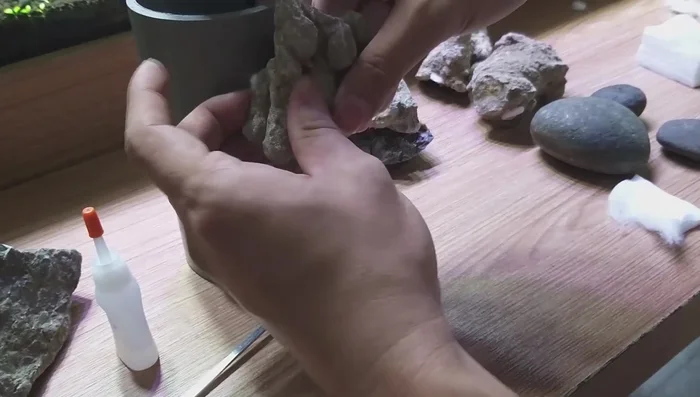 Position cotton: Insert the cotton ball into the gap between the rock and the PVC pipe, aiming for a snug fit.