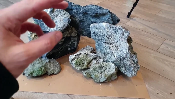 Arrange large rocks on the underlayment to create the cave structure, aiming for overhangs and crevices.