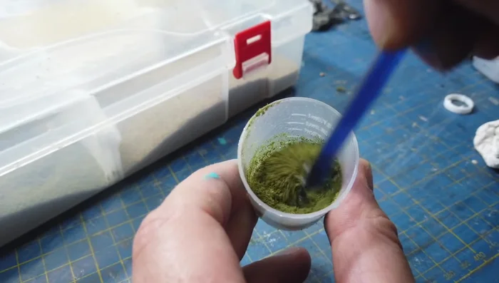 Applying moss using fine turf and scenic glue.