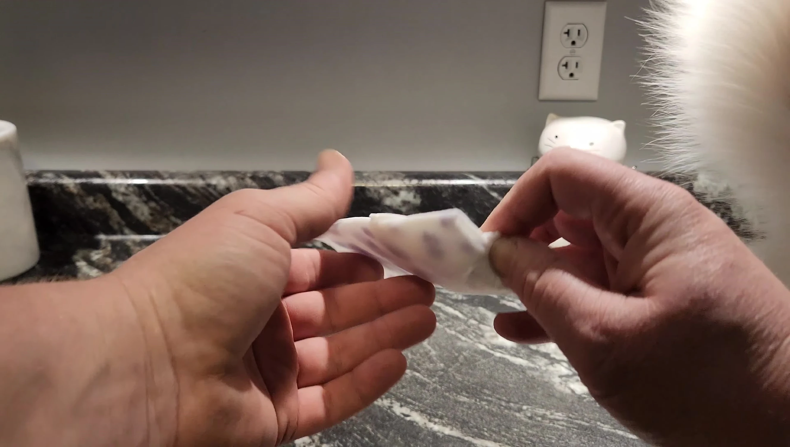 The soaked glove being removed from the package.