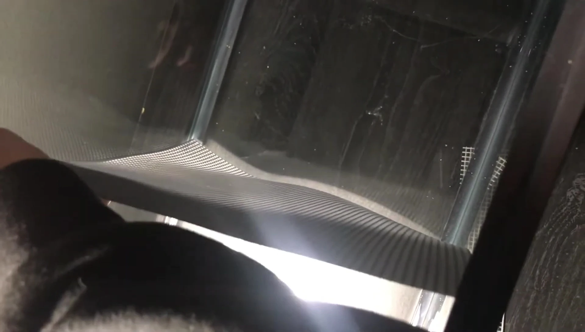Close-up of the mesh plastic piece being measured and cut.