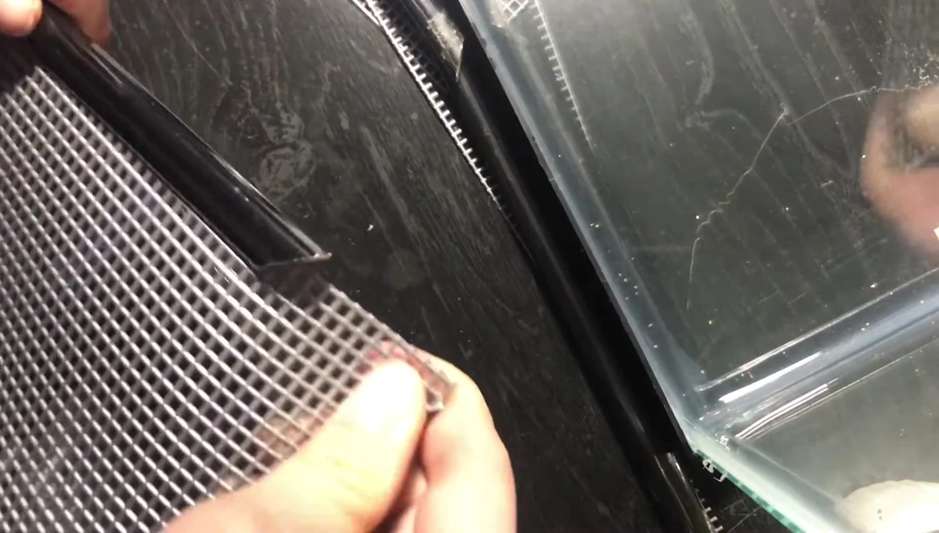 The clips being slid into position on the mesh.
