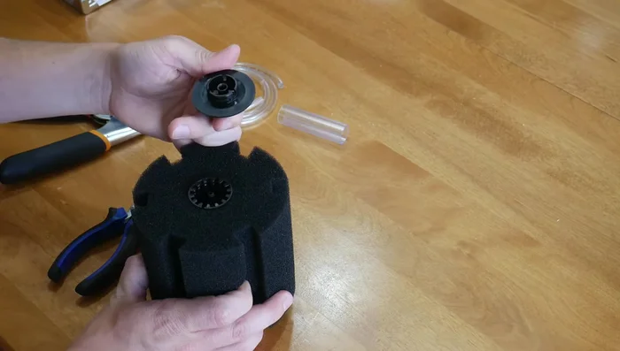 Pull off the sponge and separate the bottom weighted part from the internal working of the filter.