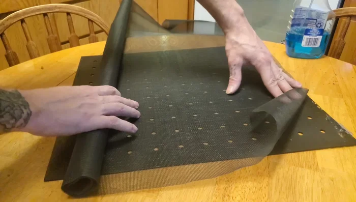 Cut the window screening slightly larger than the divider.