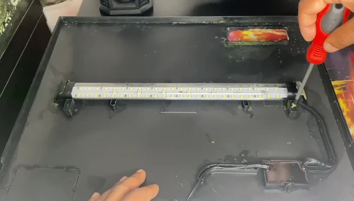 Secure the light cover with the screws.