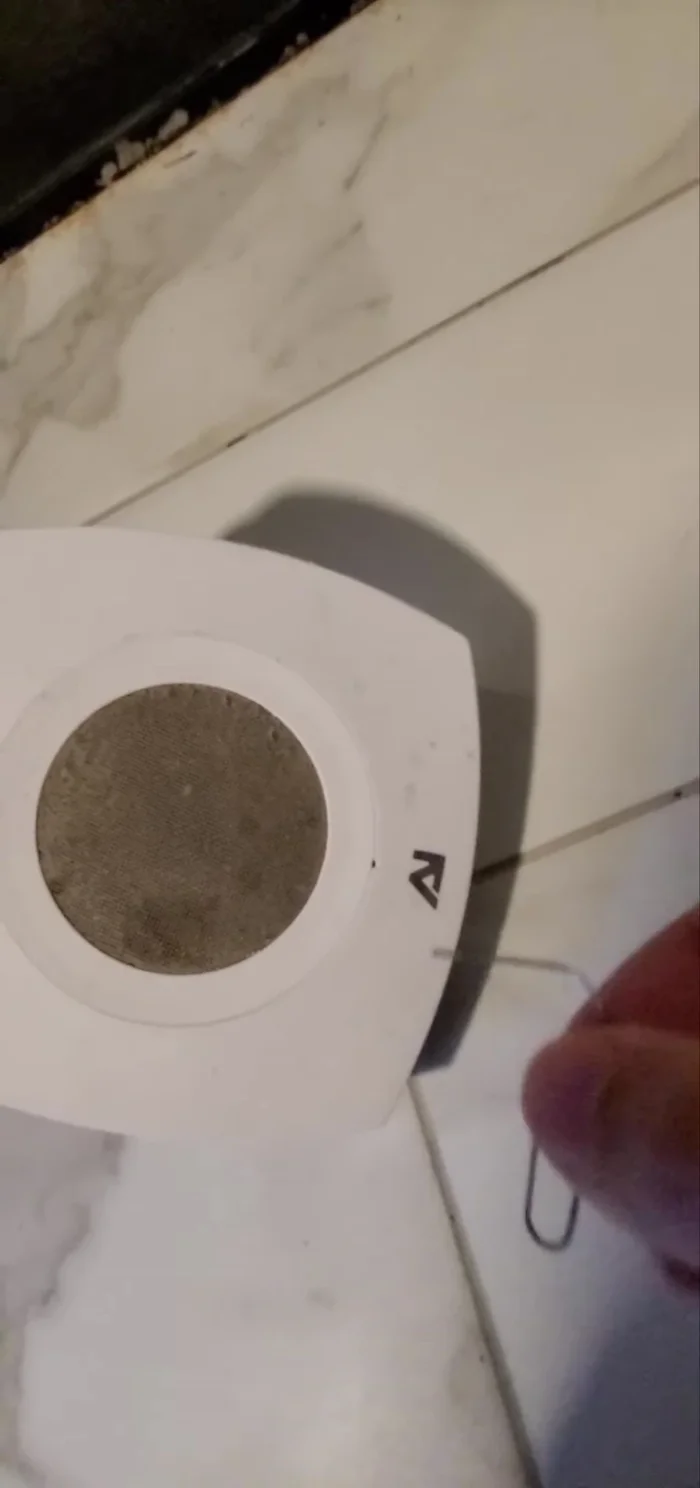 Use a pointed object, like a paper clip, to release the catch and remove the fan cover.