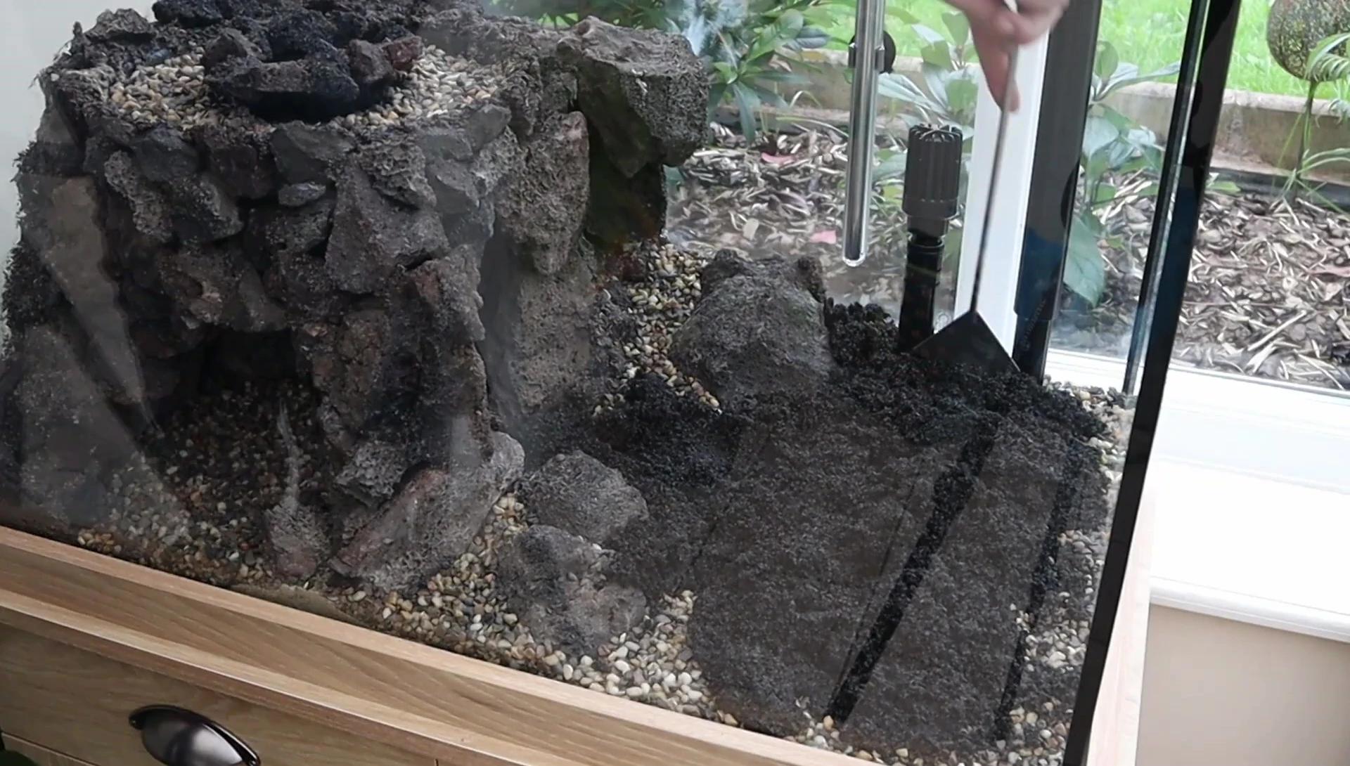 Black sand being carefully added to the aquascape.