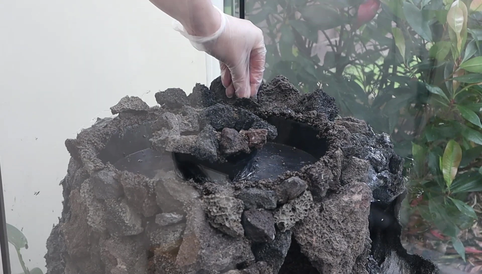Lava rocks being applied around the cave structure to create a natural look.