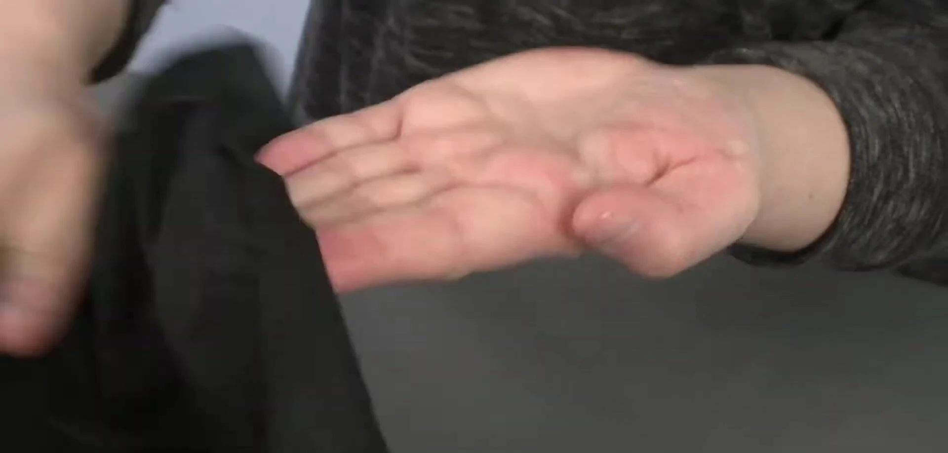 The reviewer using the wipe on their hand or demonstrating the texture.