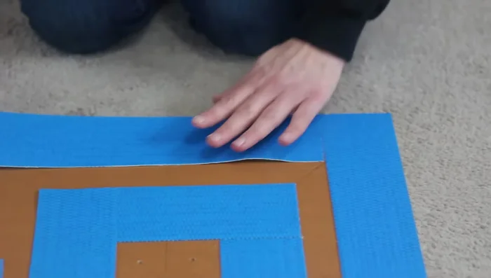 Attach the carpet to the plywood base using carpet tape (or hot glue/double-sided tape).