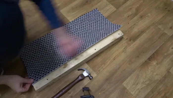 Finish the top of the post: Tuck the excess carpet at the top, cut into the corners, and secure with carpet tacks.