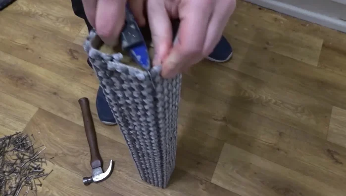 Finish the top of the post: Tuck the excess carpet at the top, cut into the corners, and secure with carpet tacks.