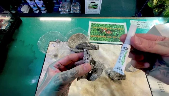 Add aquarium-safe sand or gravel to camouflage any visible glue or tissue paper.