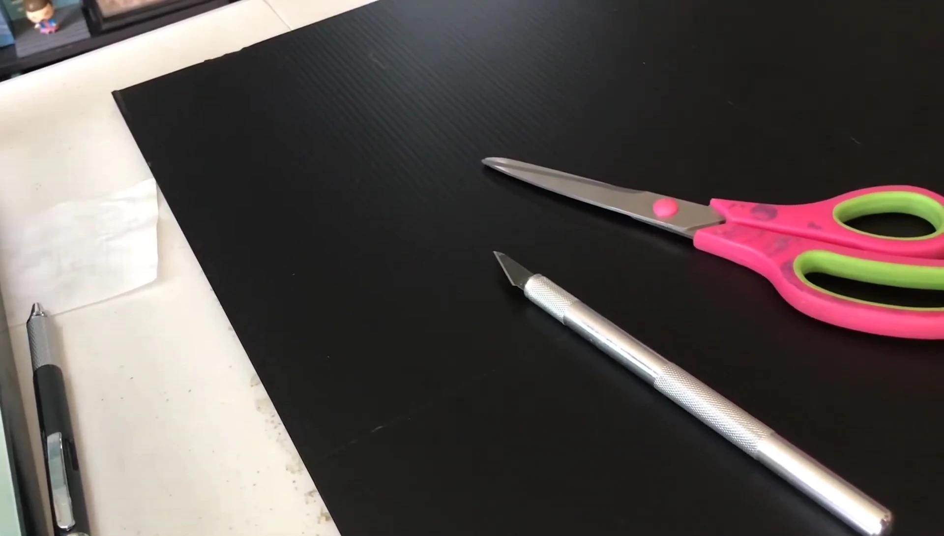 Cutting the plastic sheet with the exacto knife and scissors.