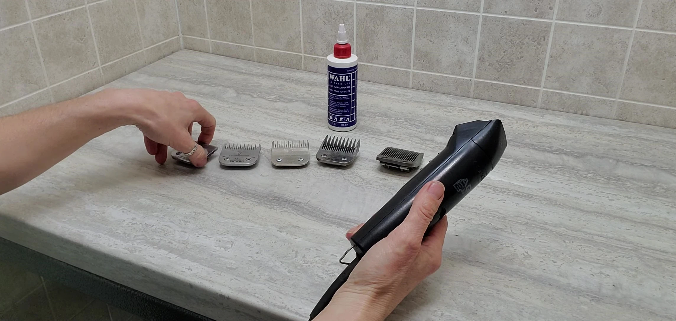 The groomer demonstrates how to remove and attach the blades.