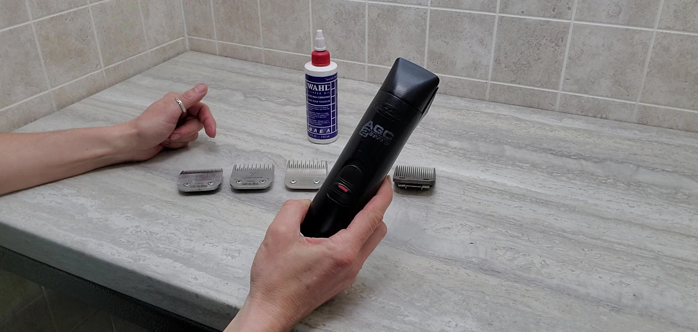 The groomer holding the Andis clippers.