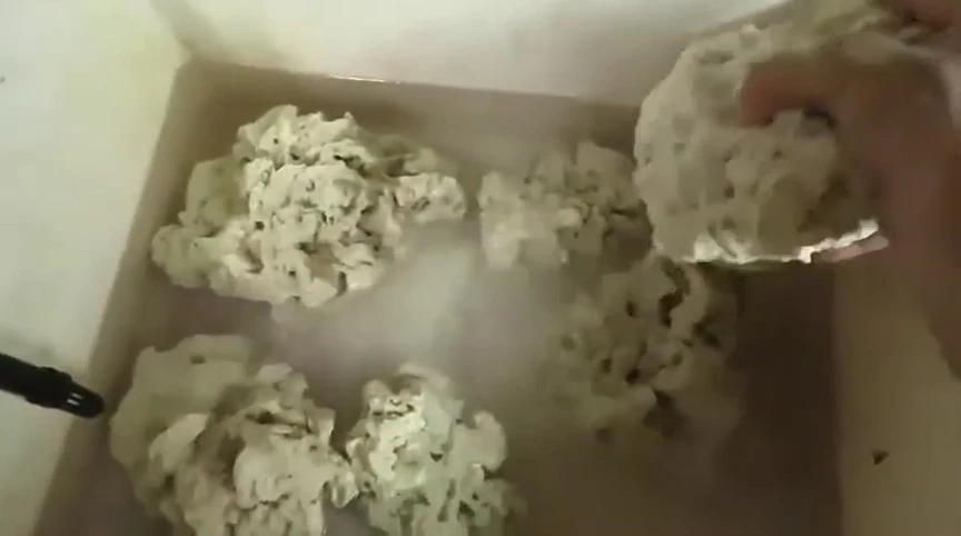 Rinsing the base rock in a sink.