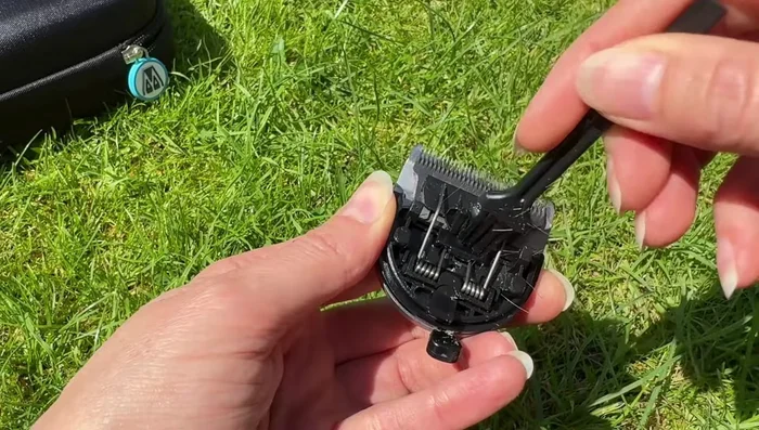 Use the brush to clean the front and back of the blade. Gently move the cutter to clean hair away from the cutting surface. Clean the narrow spaces between the teeth on the other side of the blade.